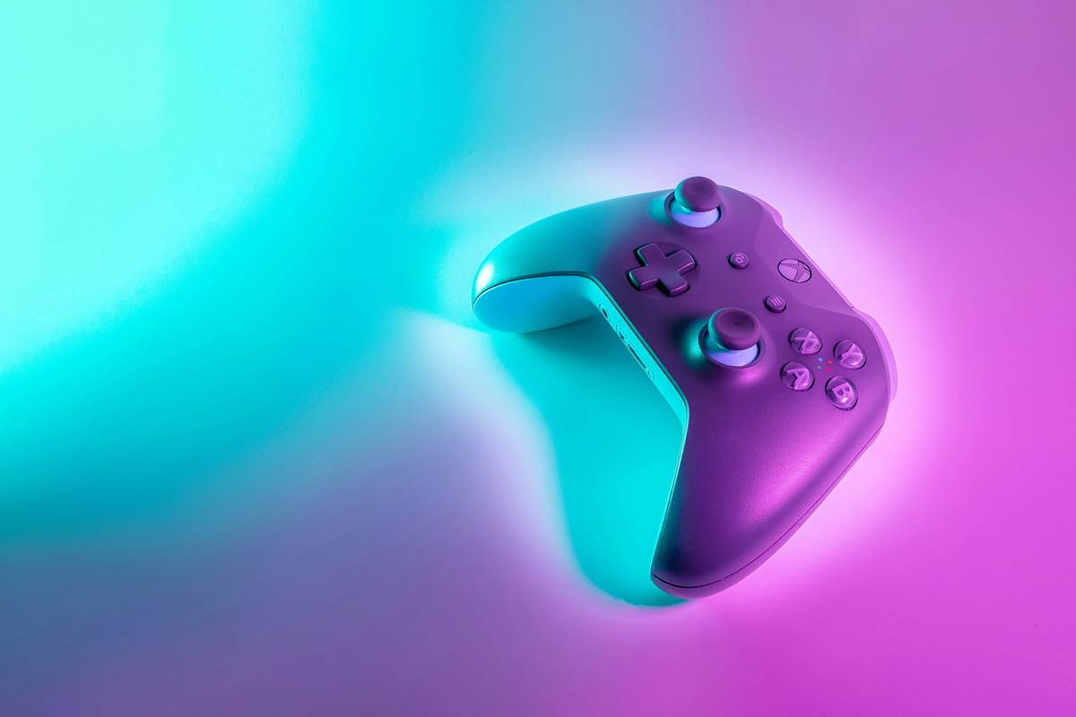 Hand holding a VR controller with gaming controller extra buttons highlighted near thumb and index fingers